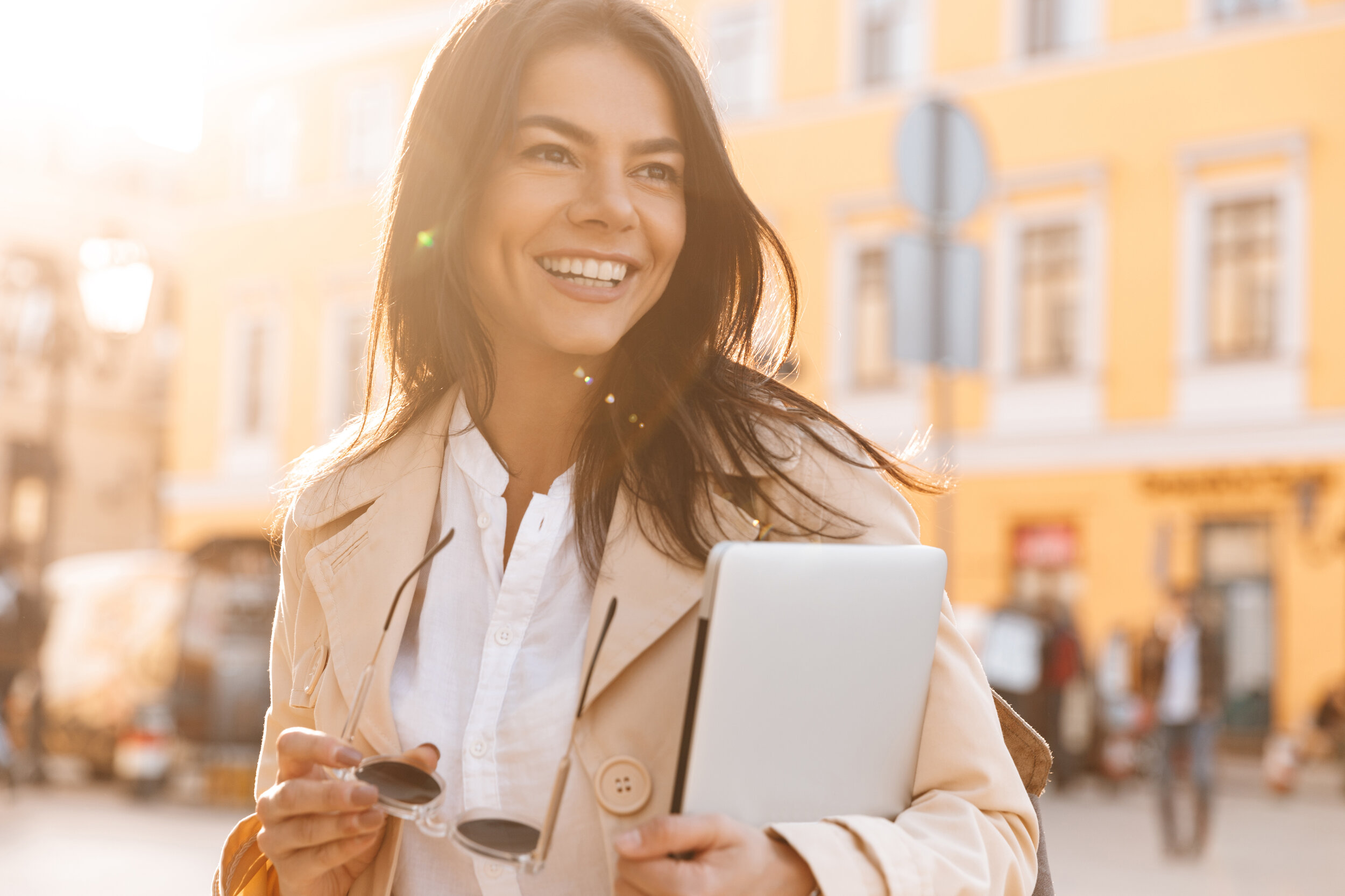 woman smiling outside with laptop
